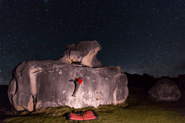photo of my friend, Neil Jenman, on the submarine boulder in Castle Hill, NZ, underneath the stars